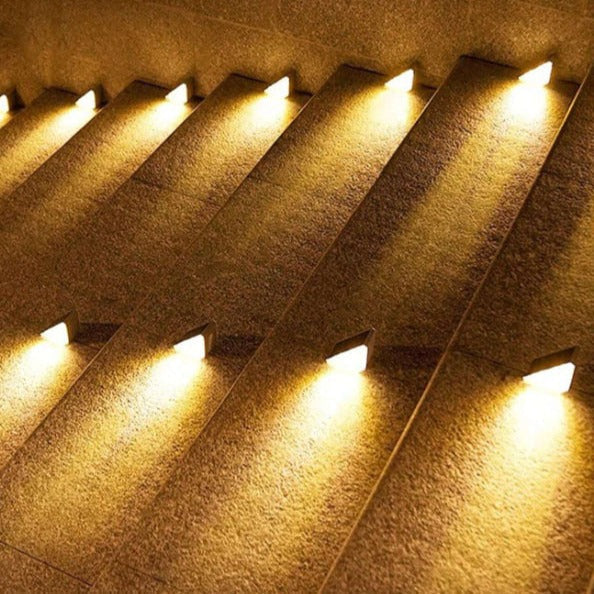 Beleuchtete Treppenstufen mit warmweißen LED-Lichtern, moderne Außenbeleuchtung, Nachtansicht.
