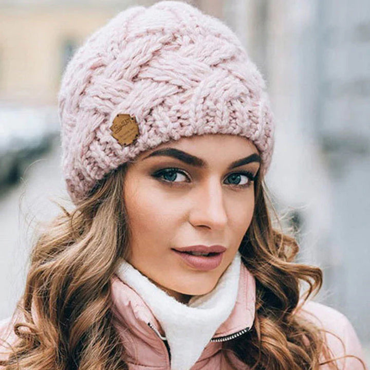 Frau mit rosa Strickmütze, Zopfmuster, Wintermode, warm, stilvoll, draußen, Stadtumgebung.