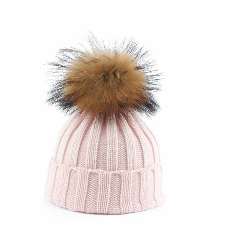 Rosa Strickmütze mit braunem Kunstfellbommel, Wintermode Accessoire, warm und stilvoll.