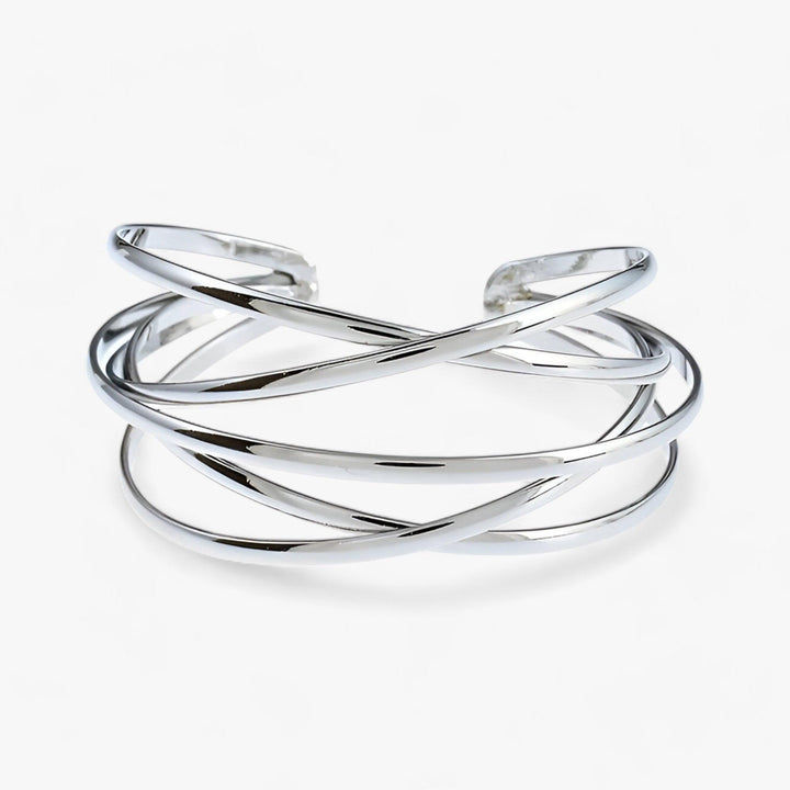 Silberner Armreif, offenes Design, überkreuzte Streifen, eleganter Schmuck, Damenaccessoire.
