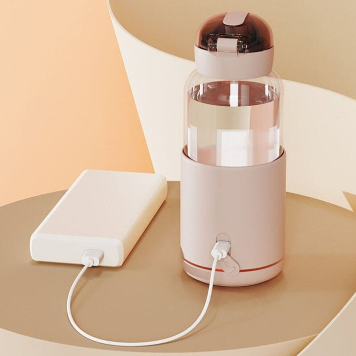 Tragbarer Wasserbecher mit Temperaturregelung, USB-Ladung, transparent, rosa Deckel.