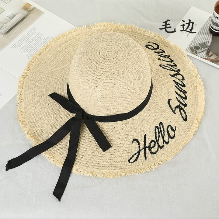 Beiger Sonnenhut mit schwarzer Schleife und "Hello Sunshine"-Stickerei, ideal für Sommermode.