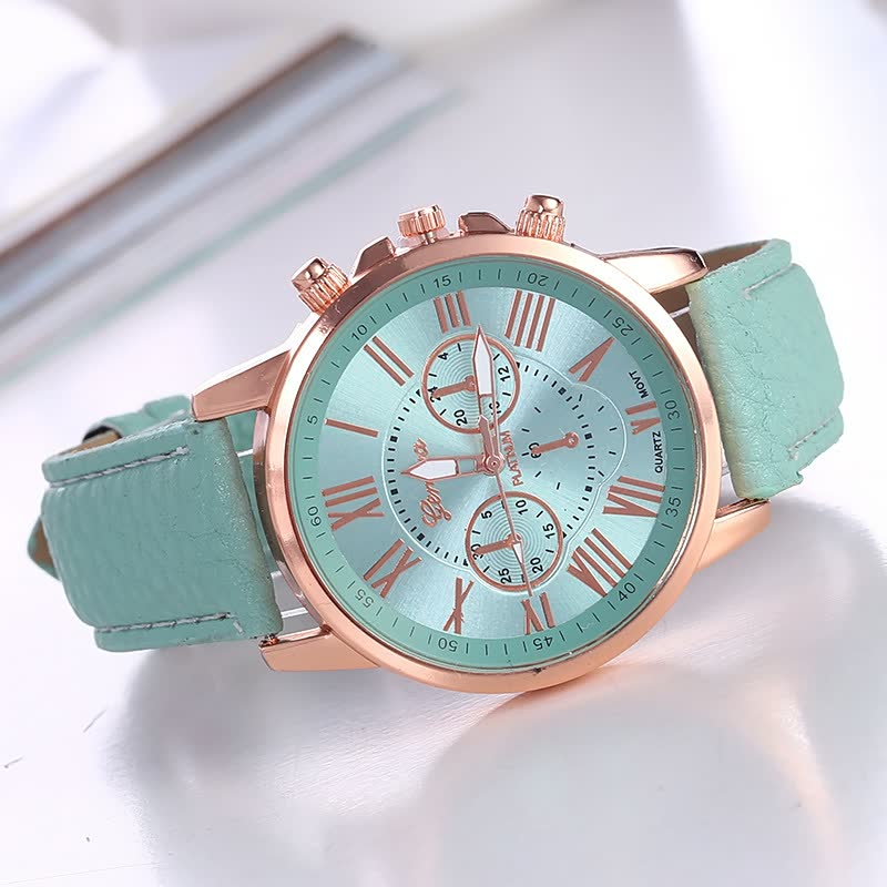Mintgrüne Armbanduhr mit römischen Ziffern, roségoldenem Gehäuse und Lederarmband.