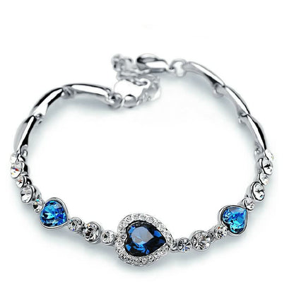 Silberarmband mit blauen Herzanhängern, Kristallen, elegantes Schmuckdesign, Damenaccessoire.