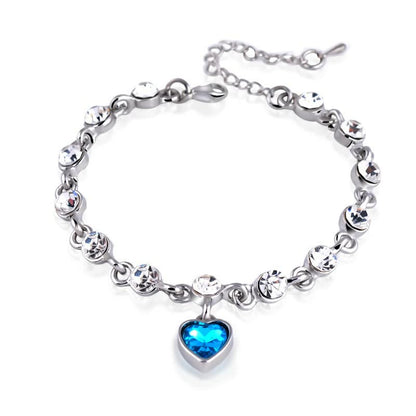 Silberarmband mit blauen Herzanhänger und klaren Kristallen, eleganter Schmuck für Damen.