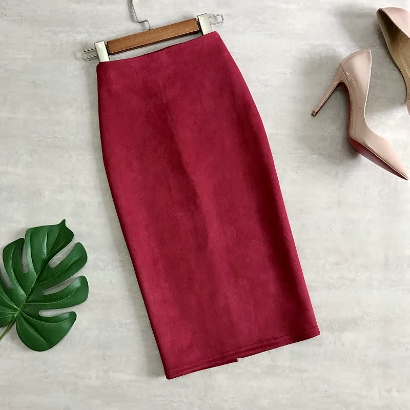 Roter Bleistiftrock aus Wildleder, knielang, elegant, Damenmode, neben beigen High Heels.