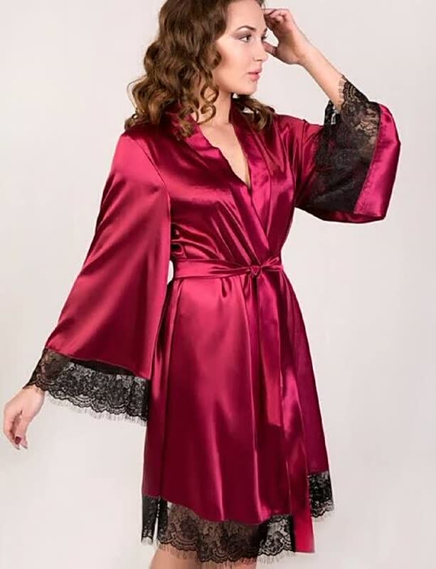 Frau in rotem Satin-Bademantel mit schwarzer Spitze, elegantes Nachtwäsche-Design.