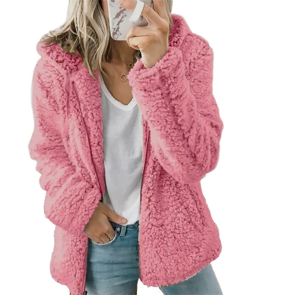 Frau in rosa Teddyfelljacke, weißem T-Shirt und Jeans, modische Winterbekleidung.