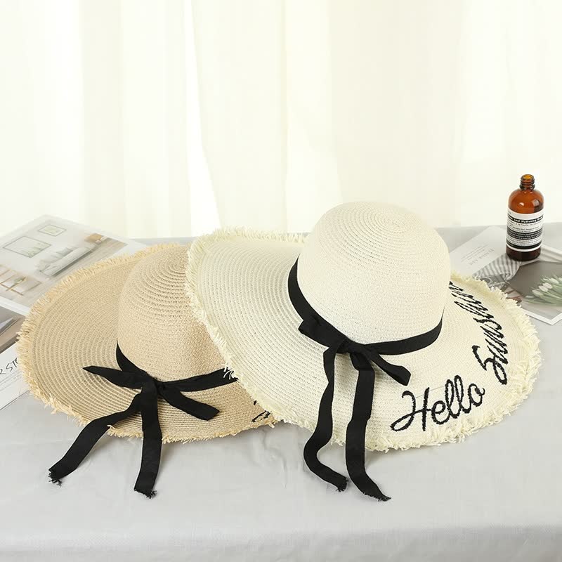 Damen Sonnenhut aus Stroh, beige und weiß, mit schwarzer Schleife und Schriftzug "Hello Summer".