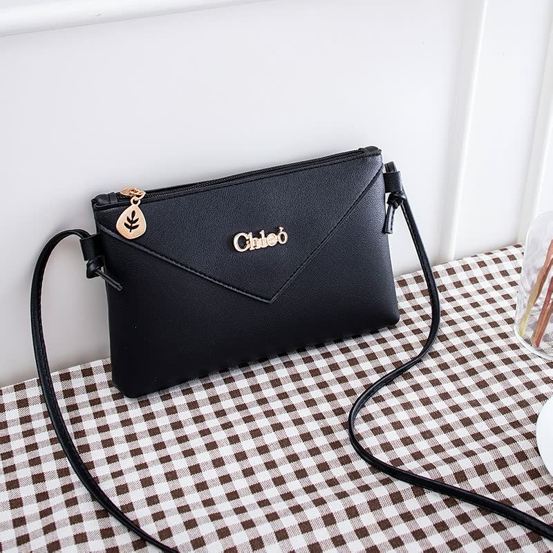 Schwarze Lederhandtasche mit Schulterriemen, goldener Reißverschluss, elegantes Design.