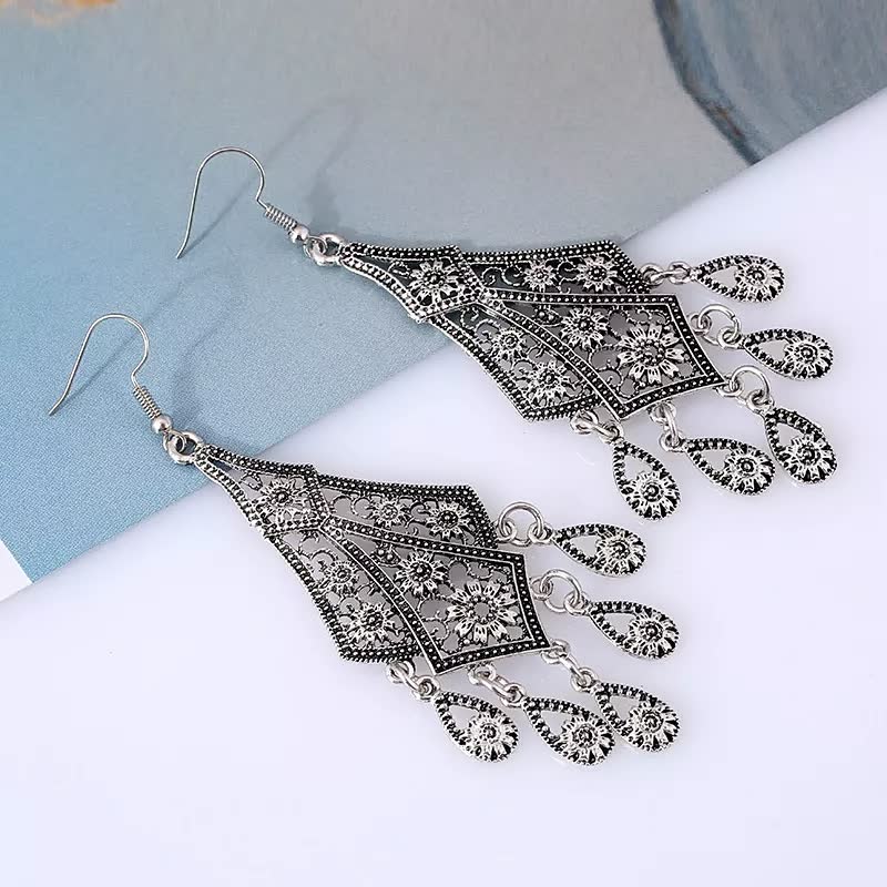 Silberne Vintage-Ohrringe mit filigranem Muster und Tropfenanhängern, Schmuckaccessoire.