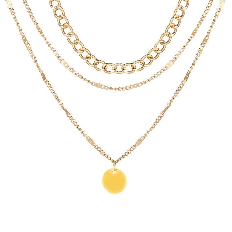 Goldene Halskette mit mehreren Schichten und rundem Anhänger, modisches Schmuckstück.