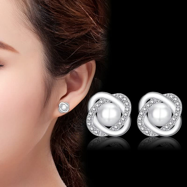 Silberne Ohrringe mit Perlen und Kristallen, eleganter Schmuck für Damen, Nahaufnahme.