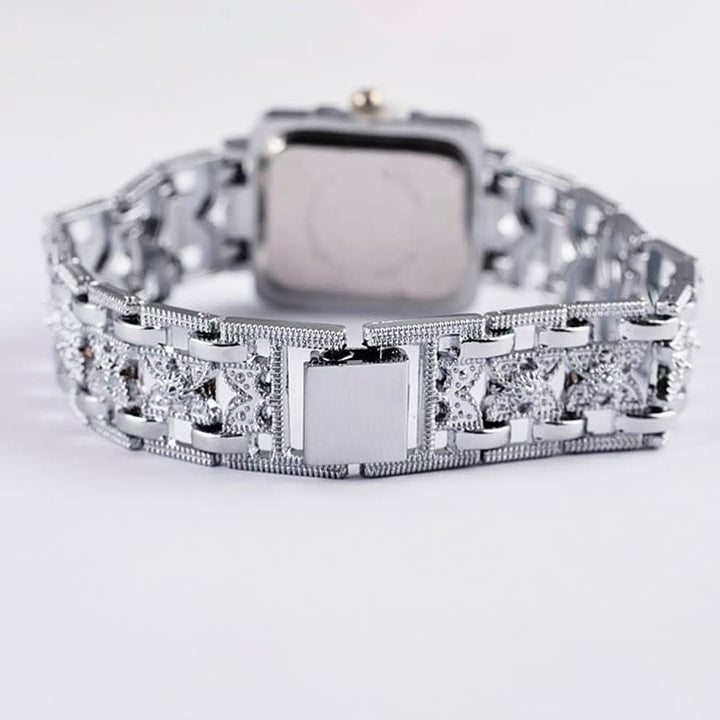 Silberne Armbanduhr mit quadratischem Zifferblatt und verziertem Gliederarmband, luxuriöses Design.