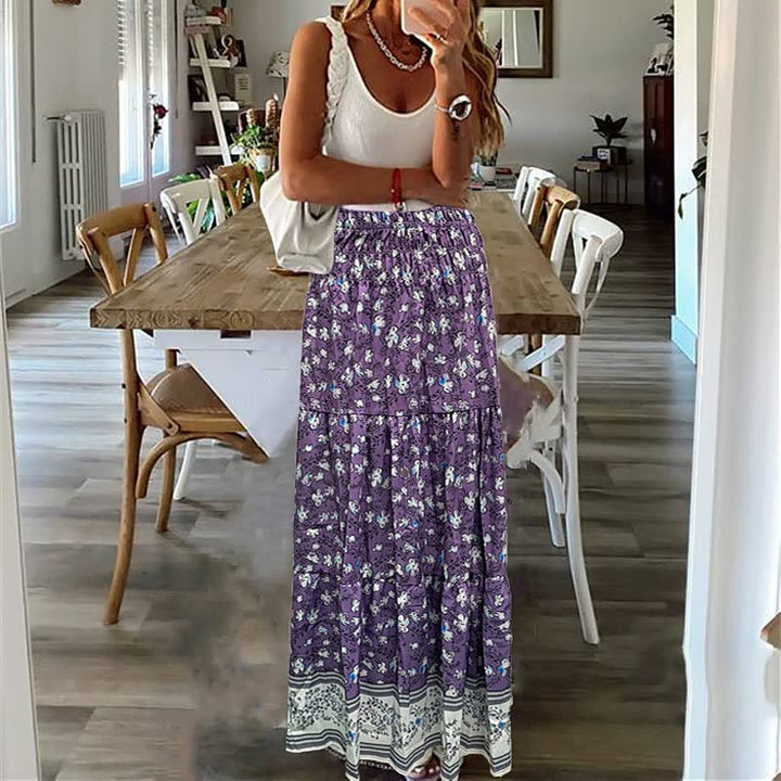 Frau in weißem Top und lila Blumenkleid in modernem Esszimmer.