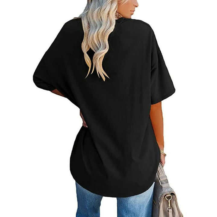 Frau in schwarzem Oversize-T-Shirt, blaue Jeans, blonde Haare, Handtasche, Rückansicht.