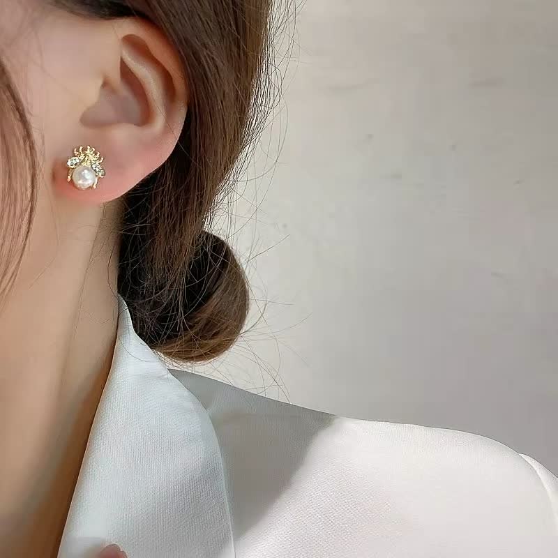 Perlenohrring mit goldener Fassung, eleganter Schmuck für Damen, klassisches Design.