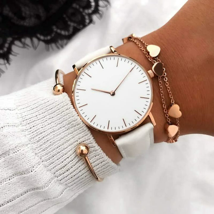 Damenarmbanduhr mit weißem Zifferblatt, roségoldenem Gehäuse und weißem Lederarmband.