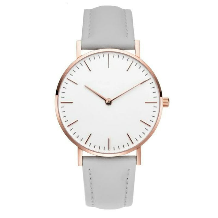Minimalistische Armbanduhr mit weißem Zifferblatt, roségoldenem Gehäuse und grauem Lederarmband.
