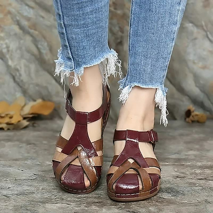 Damen Sandalen, rot-braun, Leder, T-Riemen, bequem, lässig, Sommermode, Jeans-Hintergrund.