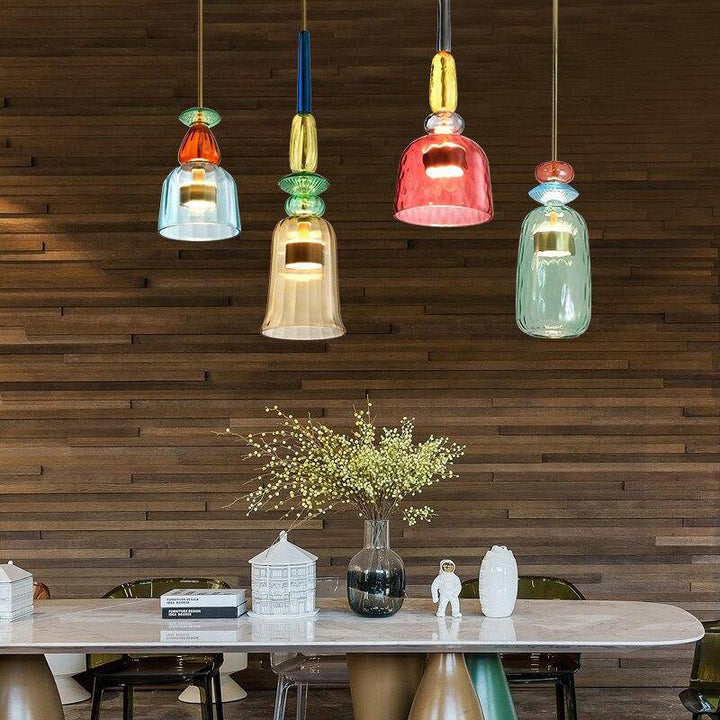 Bunte Glas-Pendelleuchten über modernem Esstisch, Holzverkleidung, stilvolle Inneneinrichtung.