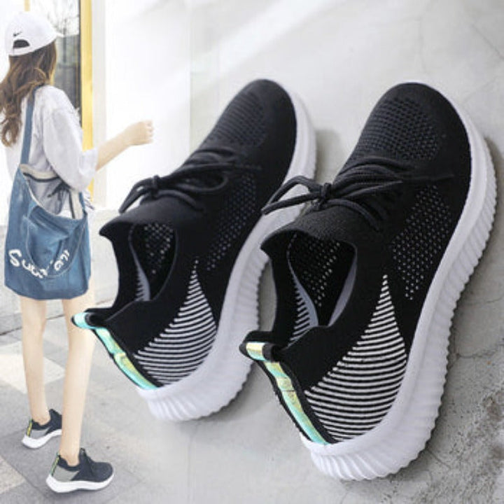 Schwarze Damen-Sneaker mit weißer Sohle, atmungsaktives Mesh, ideal für Freizeit und Sport.