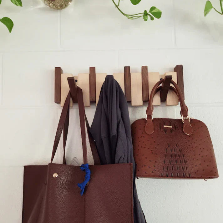 Holzgarderobe mit braunen Ledertaschen und Jacke, Wandmontage, modernes Design, platzsparend.