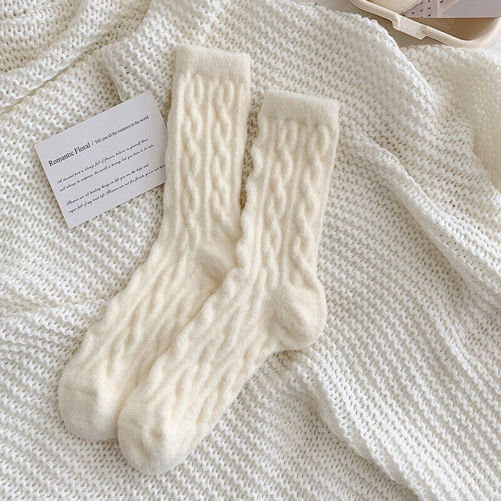 Beige Wollsocken auf gestricktem Hintergrund, warme Wintermode, gemütliche Accessoires.