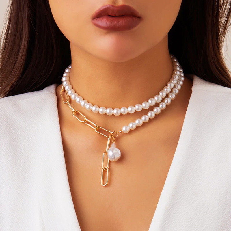 Frau mit Perlenkette und goldener Gliederkette, eleganter Schmuck, Nahaufnahme.