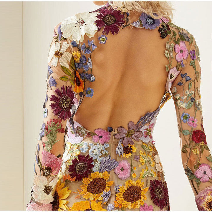 Rückenfreies Kleid mit bunten Blumenstickereien, transparentes Material, elegantes Design.