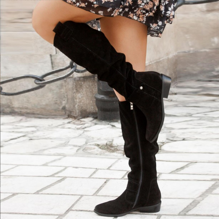 Frau trägt schwarze Wildlederstiefel, kniehoch, mit Reißverschluss, modisch, Herbstmode.