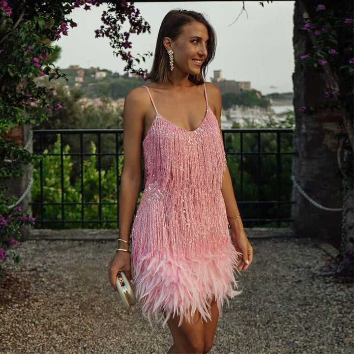 Frau im rosa Cocktailkleid mit Fransen und Federn, elegantes Abendoutfit, draußen.