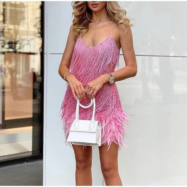 Frau in rosa Cocktailkleid mit Fransen, hält weiße Handtasche, modisch, elegant, Abendmode.