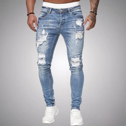 Světle modré roztrhané džíny s úzkým střihem na modelovi v bílých teniskách, pohled zepředu. 2