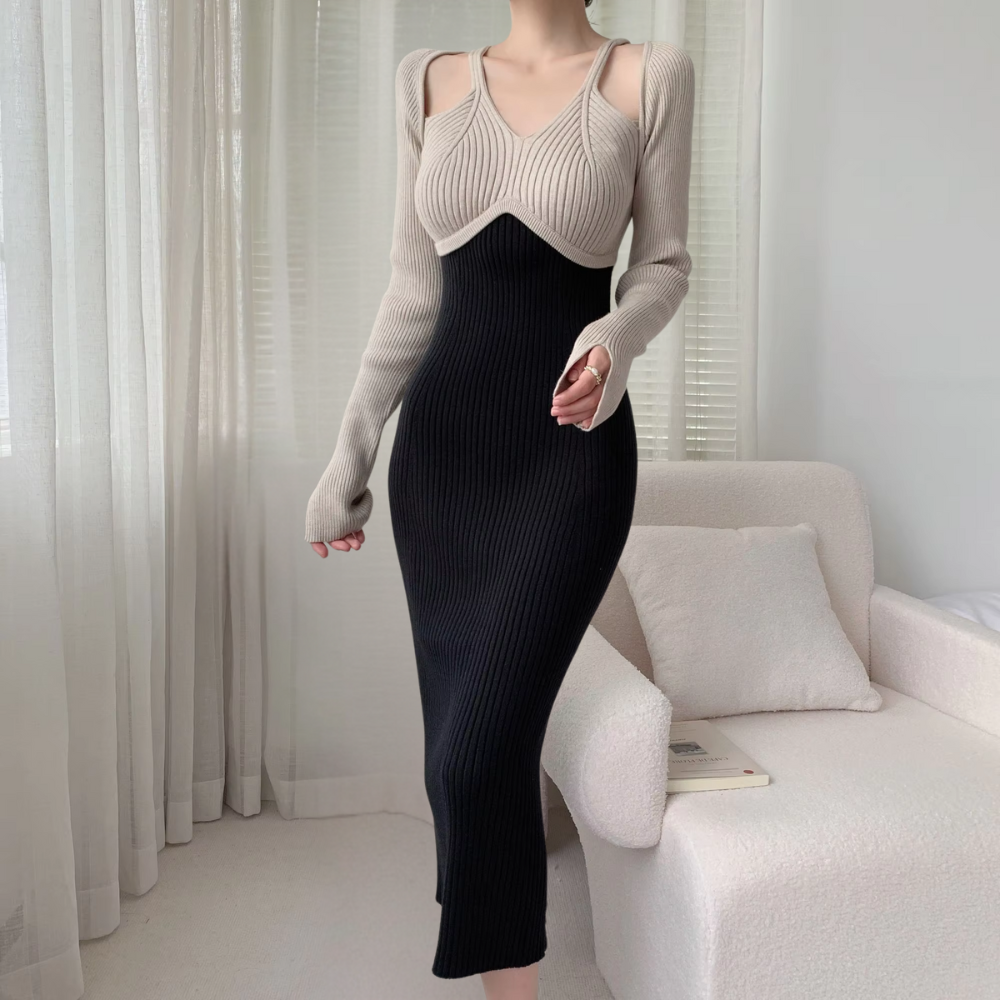 Frau in eleganter, zweifarbiger Strickkleid, beige und schwarz, im modernen Wohnzimmer.