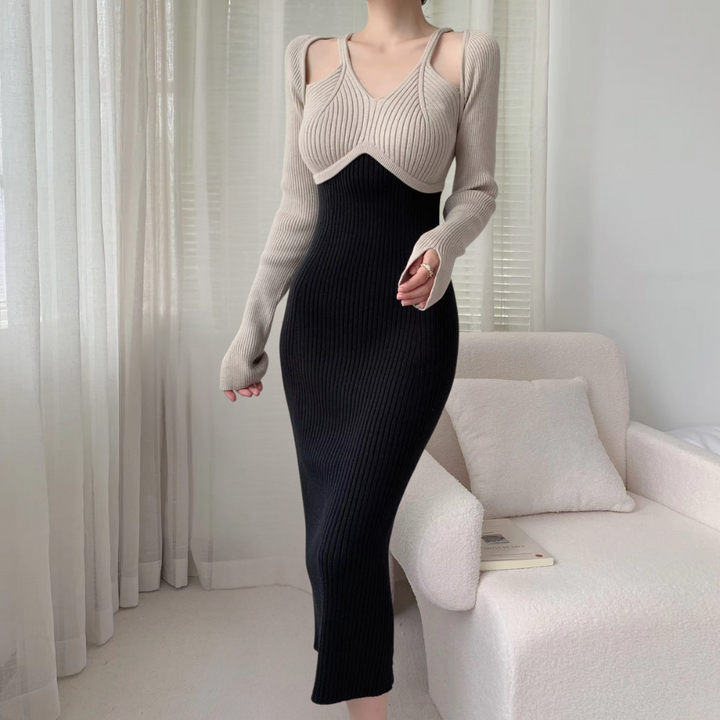 Frau in eleganter, zweifarbiger Strickkleid, beige und schwarz, im modernen Wohnzimmer.