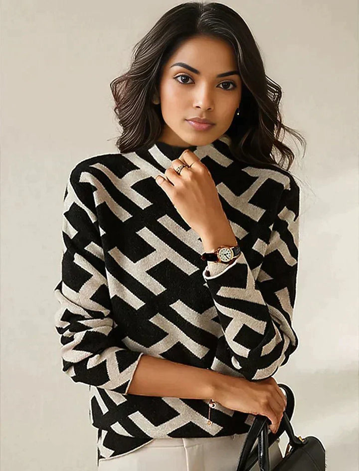 Frau trägt schwarz-weiß gemusterten Pullover, geometrisches Design, eleganter Look.