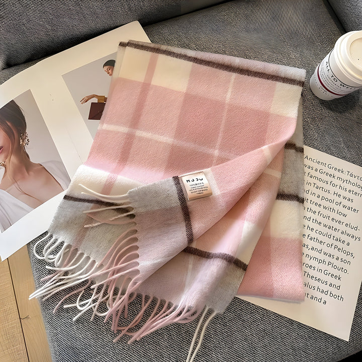 Rosa kariertes Kaschmirschal mit Fransen auf grauem Stoff, modisches Accessoire.