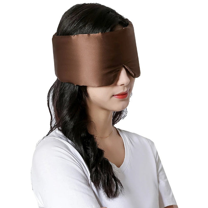 Frau trägt braune Seidenschlafmaske, ideal für Schlaf und Entspannung, komfortabel und stilvoll.