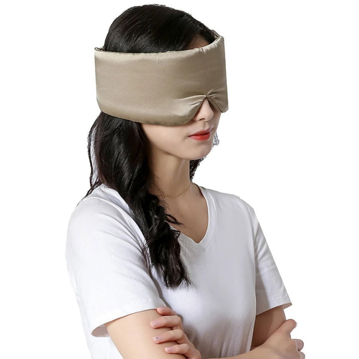 Frau mit beiger Seidenschlafmaske, ideal für Schlaf und Entspannung.