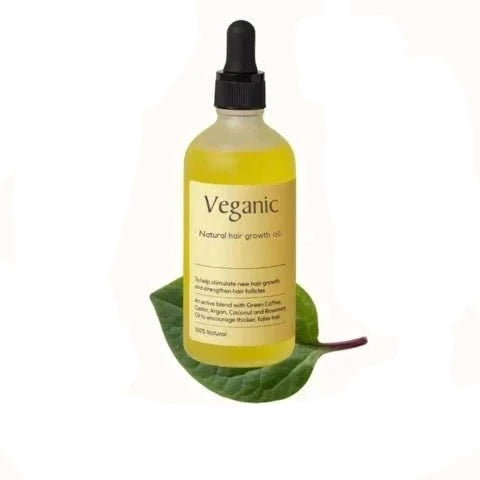 Veganic natürliche Haarwuchsölflasche, gelb, mit Pipette, auf grünem Blatt, vegan, 100% natürlich.
