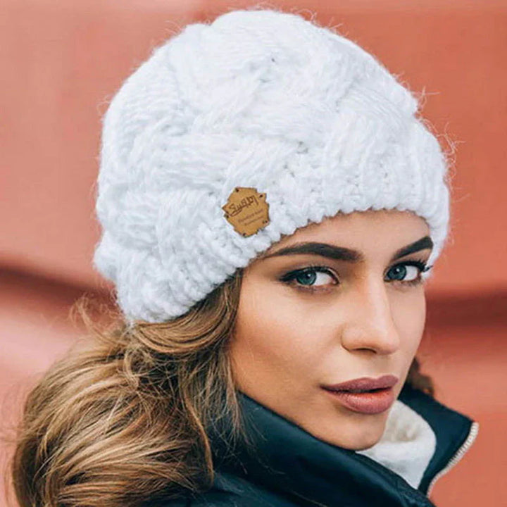 Frau mit weißer Strickmütze, Wintermode, warm, stilvoll, Damenaccessoire, Outdoor-Bekleidung.