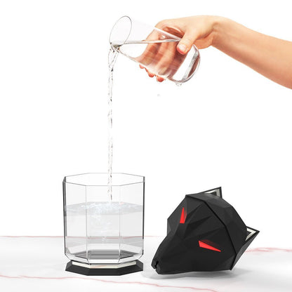Schwarzer Wolf-Luftbefeuchter, geometrisches Design, Wasser wird in Glas gegossen.