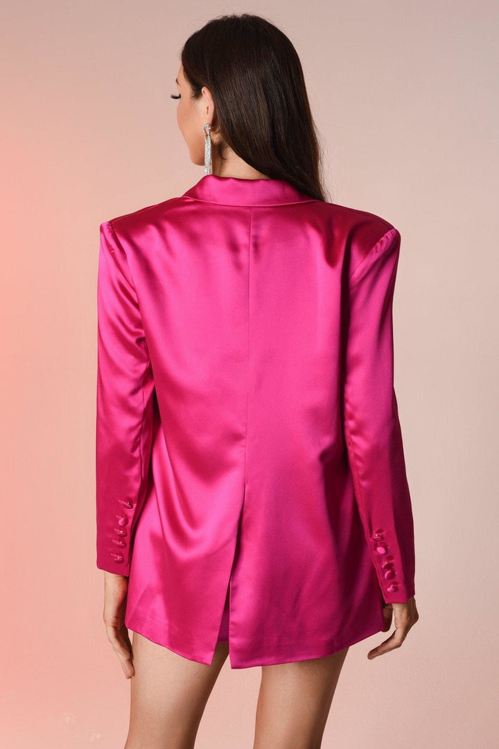 Frau in pinkem Satinblazer mit langen Ärmeln, eleganter Mode, Rückansicht.