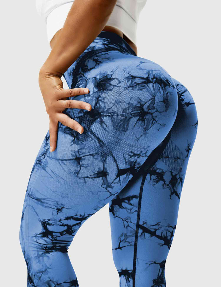 Frau in blauen, marmorierten Leggings, Sportbekleidung, Fitnessmode, elastisch, figurbetont.