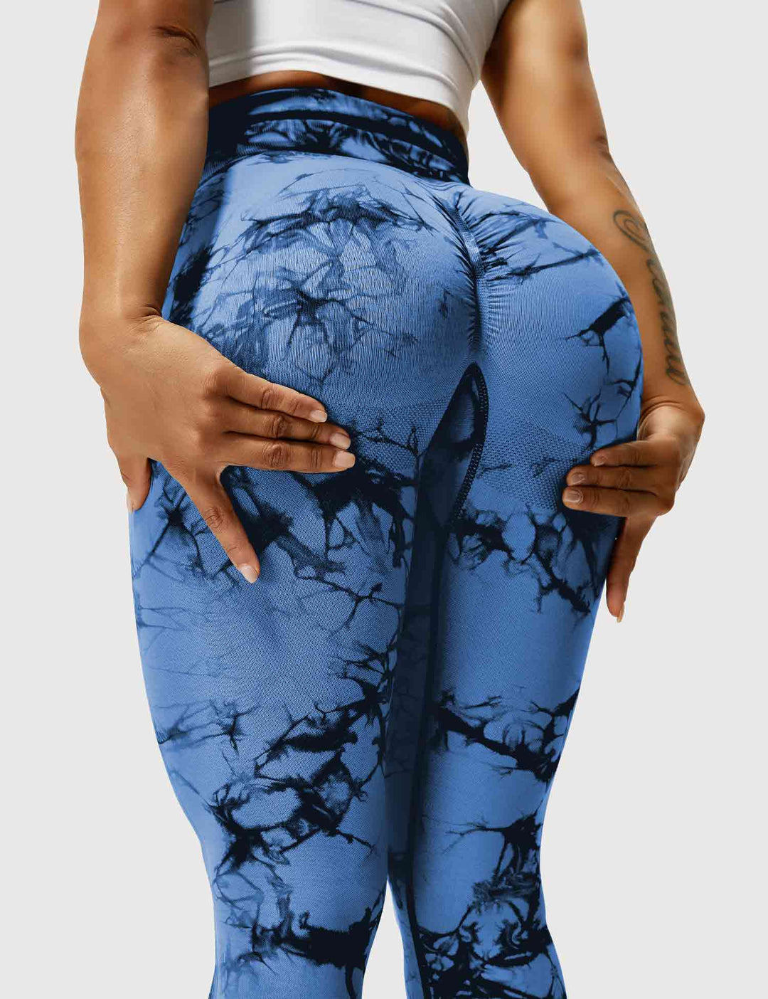 Frau in blauen Batik-Leggings, Sportbekleidung, Fitnessmode, elastisch, bequem.