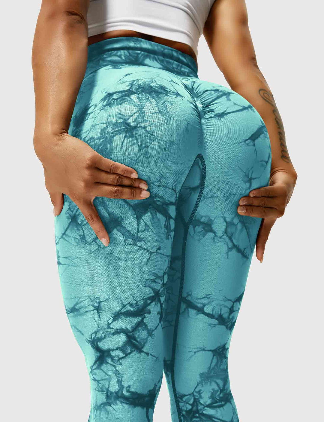 Frau in cyanblauen Leggings mit Marmormuster, Sportbekleidung, Fitnessmode.
