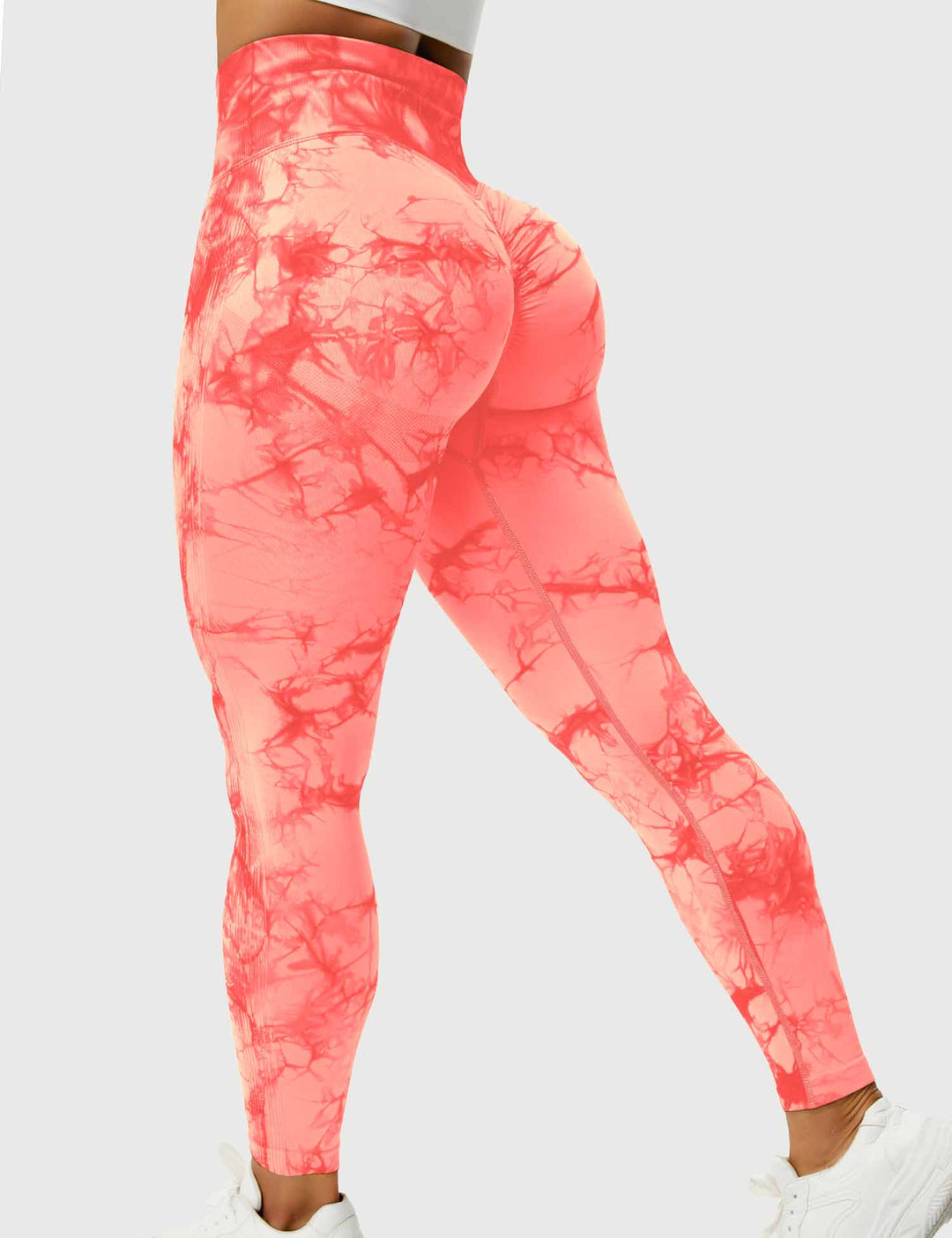 Frau in orange-rot gemusterten Leggings, Sportbekleidung, hohe Taille, elastisch, bequem.