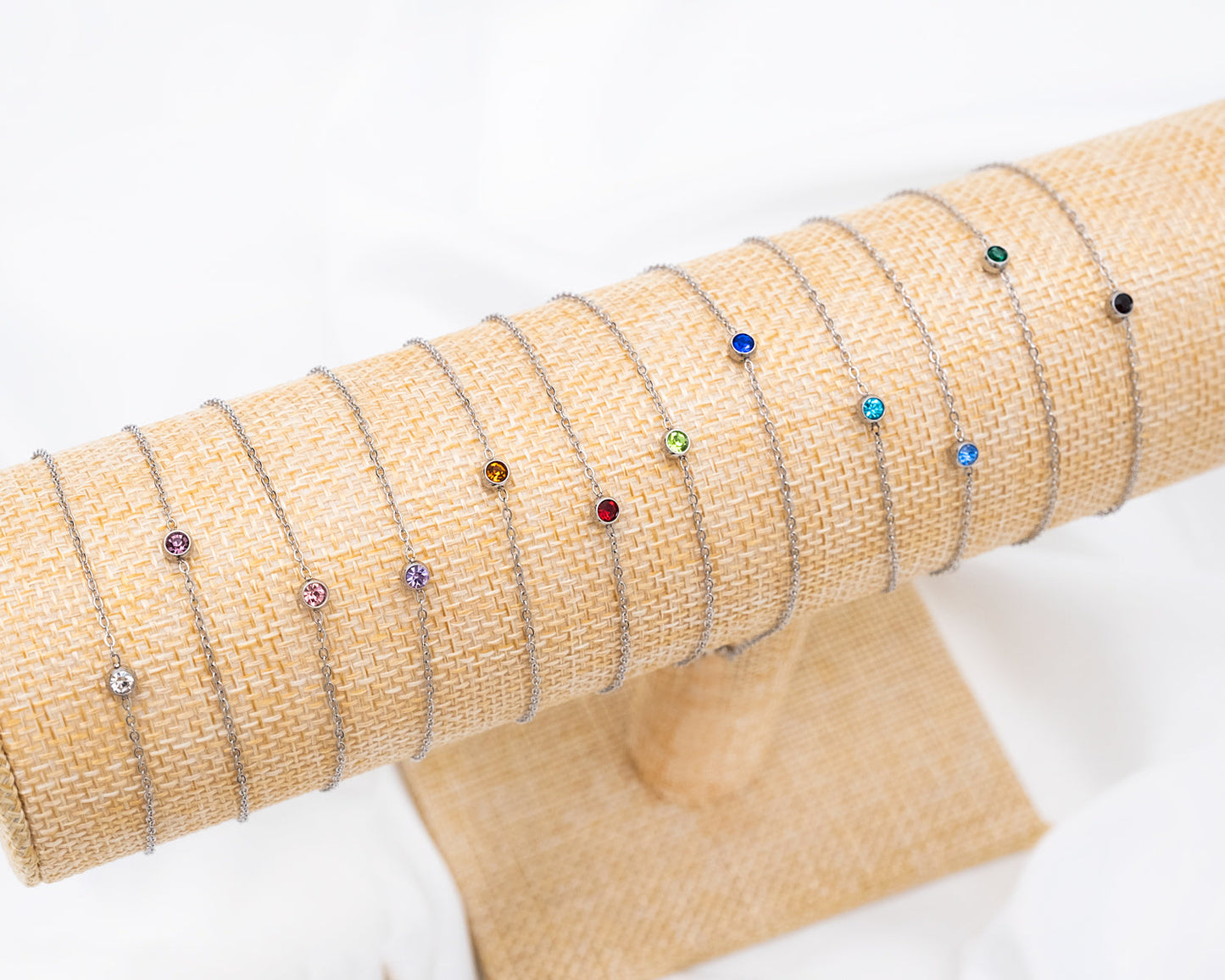 Silberne Armbänder mit Geburtssteinen auf Stoffdisplay, Schmuck, Geschenkideen, modisch.